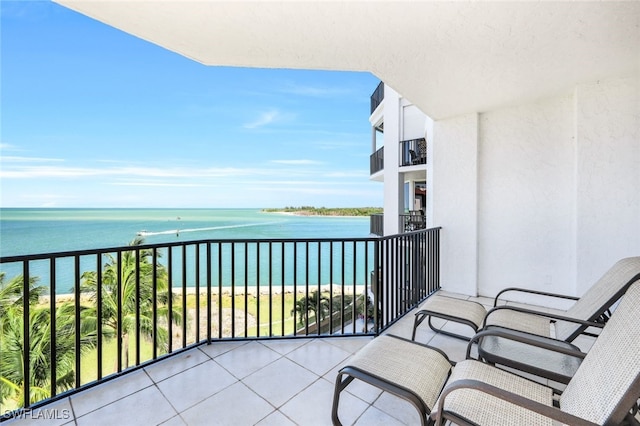 balcony with a water view and a view of the beach