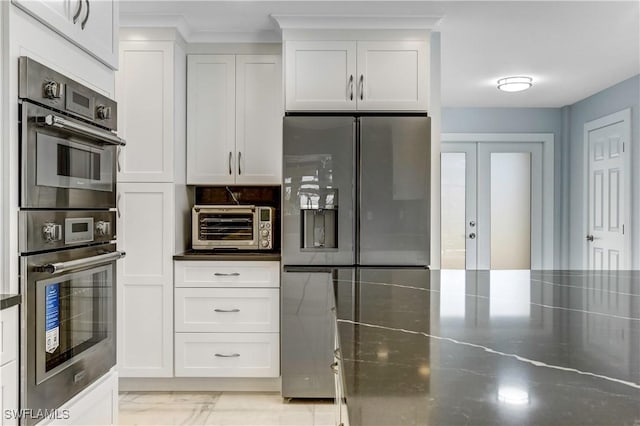 kitchen featuring backsplash, white cabinetry, stainless steel appliances, and stainless steel counters