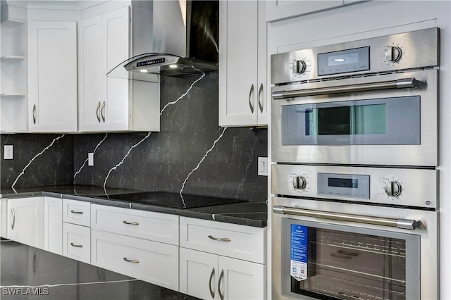 kitchen with backsplash, white cabinets, and wall chimney exhaust hood