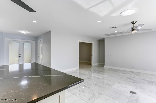 empty room with ceiling fan and french doors