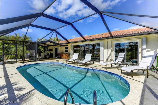 view of swimming pool with glass enclosure and a patio