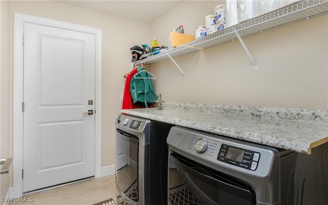 laundry area with light tile patterned floors and washer and clothes dryer