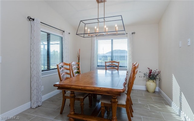 tiled dining space featuring lofted ceiling and a notable chandelier