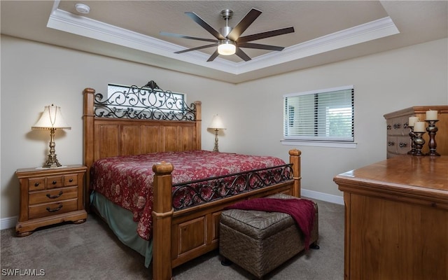 bedroom featuring carpet flooring, a tray ceiling, ceiling fan, and ornamental molding