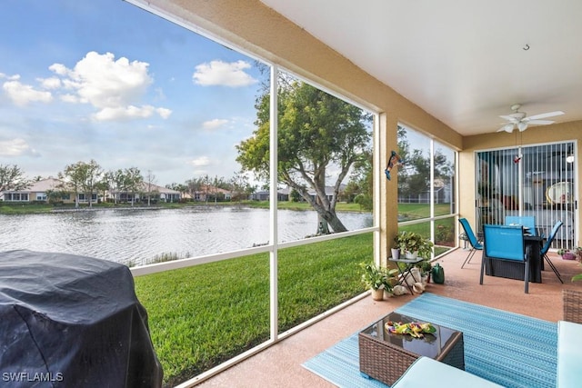 sunroom with a water view and ceiling fan