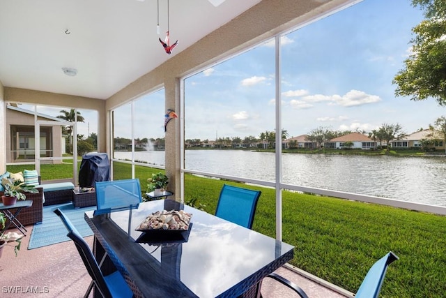 sunroom / solarium featuring plenty of natural light and a water view