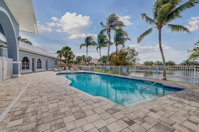 view of pool with a patio area and a water view