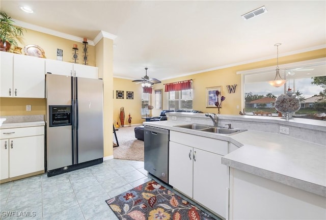 kitchen with white cabinetry, sink, hanging light fixtures, crown molding, and appliances with stainless steel finishes