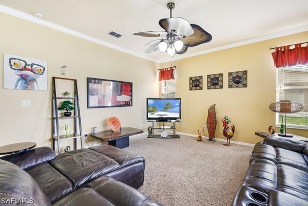 living room with ceiling fan, carpet, and ornamental molding