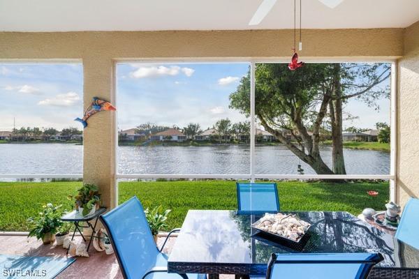 sunroom featuring ceiling fan, a water view, and a healthy amount of sunlight