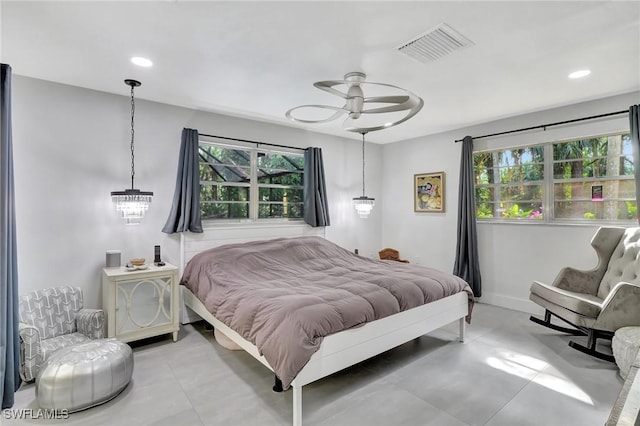 bedroom with ceiling fan with notable chandelier and multiple windows