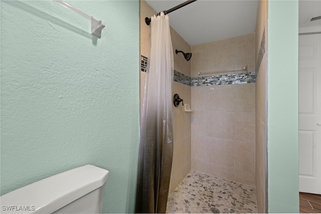 bathroom with toilet and walk in shower