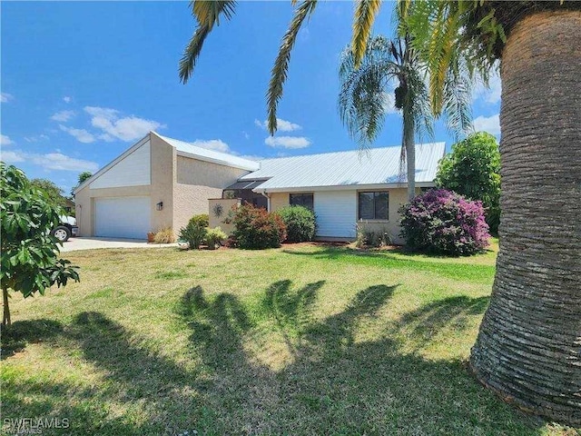 15188 Sam Snead Ln, North Fort Myers, FL 33917 - ranch-style home featuring metal roof, a front yard, concrete driveway, an attached garage, and stucco siding
