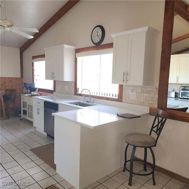 kitchen featuring kitchen peninsula, white cabinetry, dishwasher, and sink