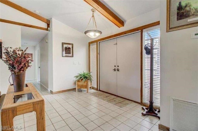 entryway with vaulted ceiling with beams and light tile patterned flooring