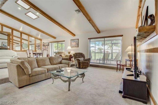 carpeted living room with beam ceiling, high vaulted ceiling, and a healthy amount of sunlight