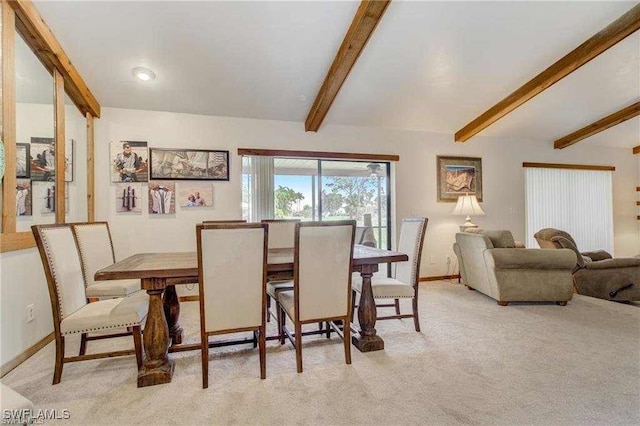 dining room with light carpet and beam ceiling