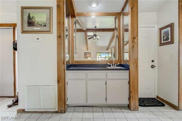 kitchen featuring ceiling fan, sink, light tile patterned floors, vaulted ceiling with beams, and white cabinets