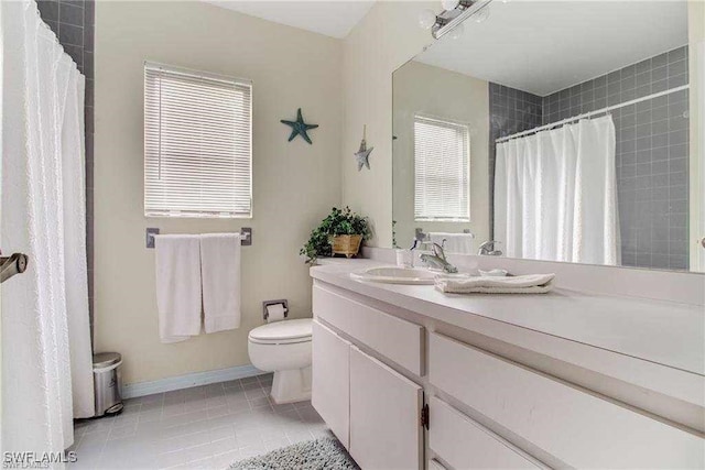 bathroom featuring tile patterned flooring, vanity, and toilet