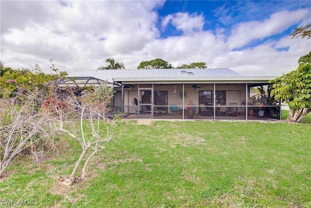 back of house featuring a lawn and a sunroom