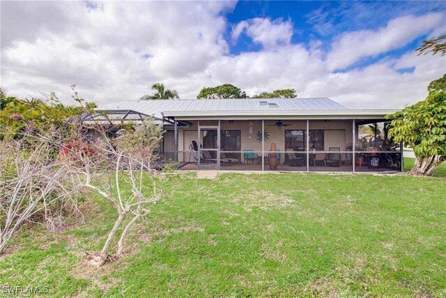 15188 Sam Snead Ln, North Fort Myers, FL 33917 - back of house featuring a ceiling fan, a yard, a sunroom, and metal roof