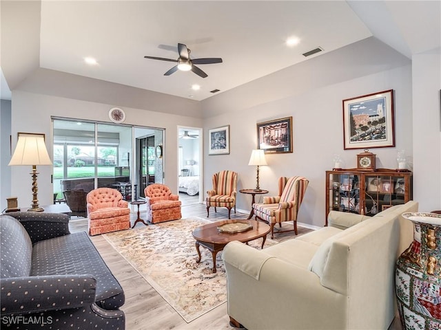 living room featuring ceiling fan, light hardwood / wood-style floors, and vaulted ceiling