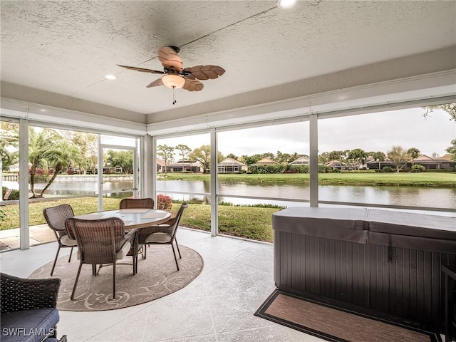 sunroom / solarium featuring ceiling fan, a water view, and a jacuzzi