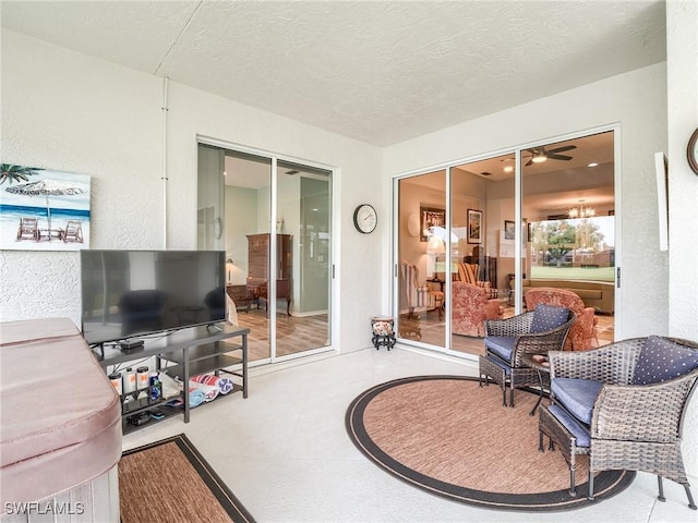 living room featuring ceiling fan and a textured ceiling