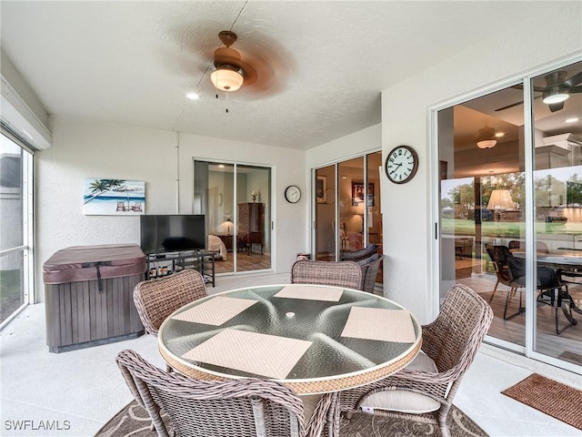 view of patio with ceiling fan and a hot tub