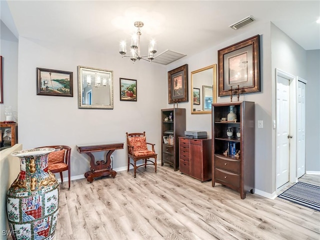 sitting room with light wood-type flooring and a chandelier