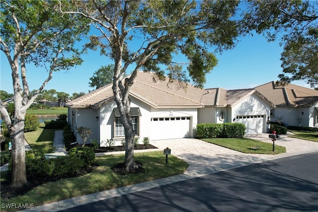 single story home with a garage and a front lawn