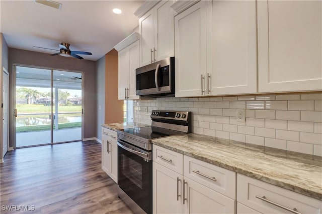 kitchen with decorative backsplash, ceiling fan, light stone countertops, appliances with stainless steel finishes, and white cabinetry