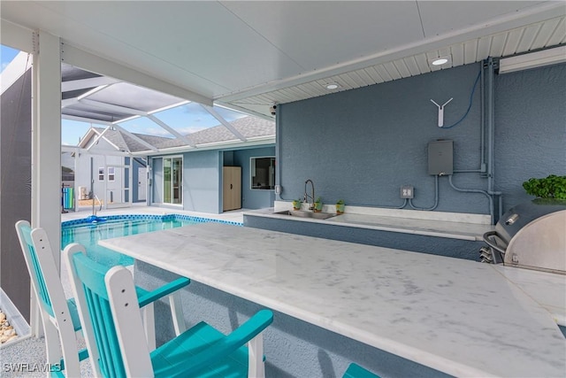 view of swimming pool featuring sink, a lanai, and a patio area