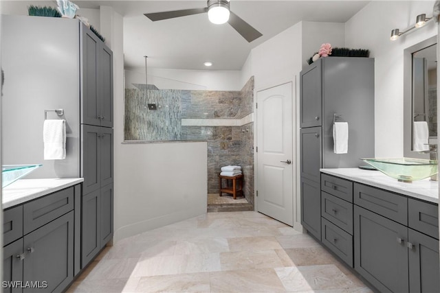 bathroom with vanity, ceiling fan, and tiled shower