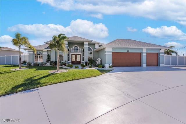 view of front of property featuring a garage, a front lawn, and french doors