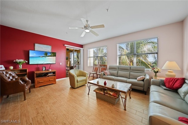 living room with light hardwood / wood-style floors and ceiling fan