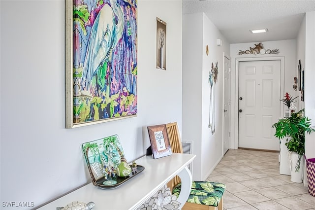 foyer entrance featuring light tile patterned flooring and a textured ceiling