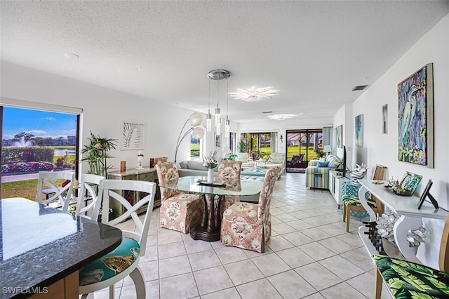 dining space with light tile patterned flooring and a textured ceiling