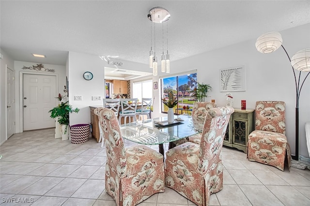 tiled dining room featuring a textured ceiling