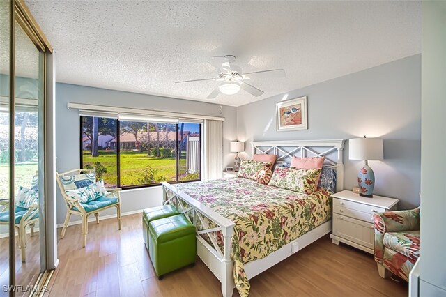 bedroom with ceiling fan, light hardwood / wood-style flooring, and a textured ceiling