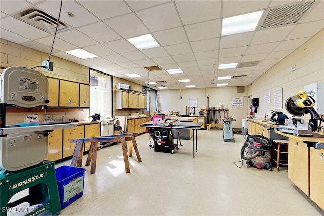 interior space featuring a workshop area and a drop ceiling