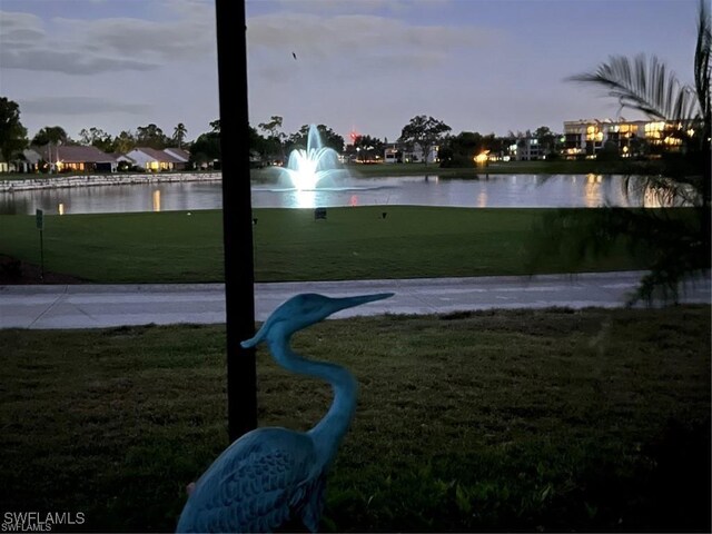 view of property's community with a yard and a water view