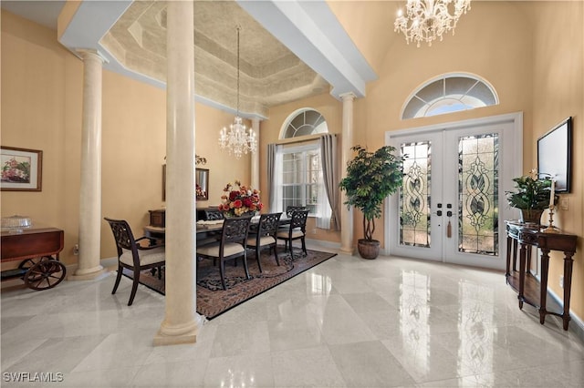 interior space with ornate columns, french doors, and a towering ceiling