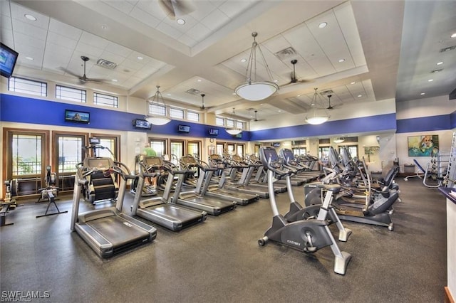 exercise room featuring a paneled ceiling, ceiling fan, a high ceiling, and coffered ceiling