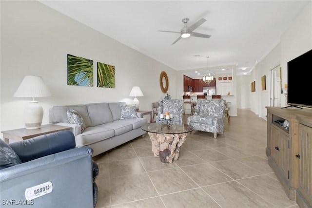 tiled living room featuring ceiling fan with notable chandelier