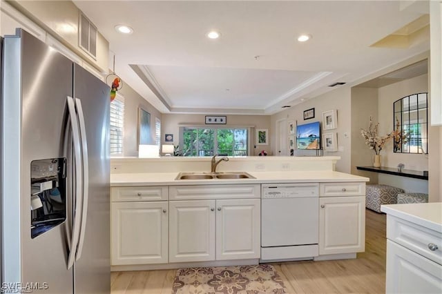 kitchen with a raised ceiling, dishwasher, stainless steel refrigerator with ice dispenser, and sink