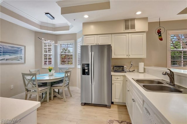 kitchen featuring ornamental molding, a tray ceiling, sink, white cabinets, and stainless steel fridge with ice dispenser