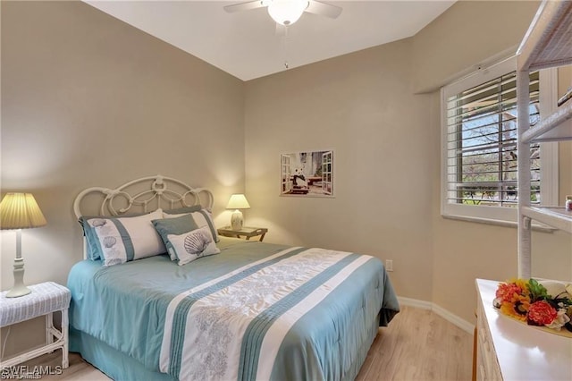 bedroom with ceiling fan, lofted ceiling, and light wood-type flooring