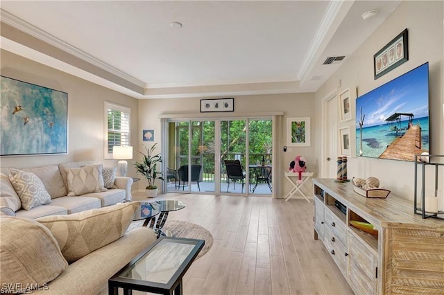 living room featuring a tray ceiling, light hardwood / wood-style flooring, and ornamental molding