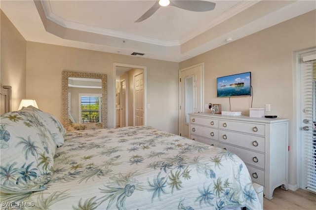 bedroom with a raised ceiling, ceiling fan, and ornamental molding